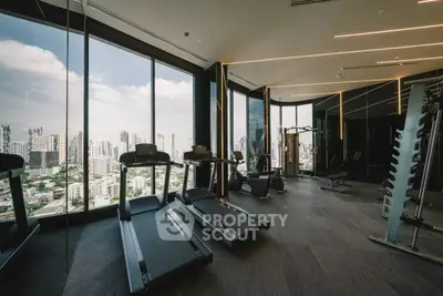Luxurious high-rise gym with panoramic city views and modern fitness equipment.