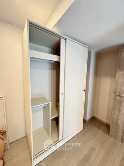 Spacious modern wardrobe in a bright room with wooden flooring, perfect for organized storage.
