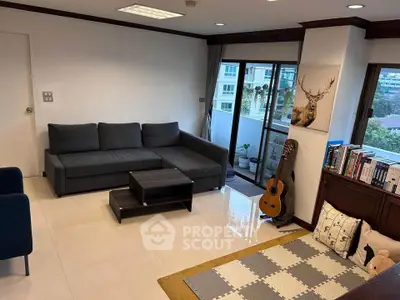Spacious living room with modern sofa, guitar, and balcony view in a stylish apartment.