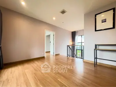 Spacious modern living room with wooden flooring and ample natural light