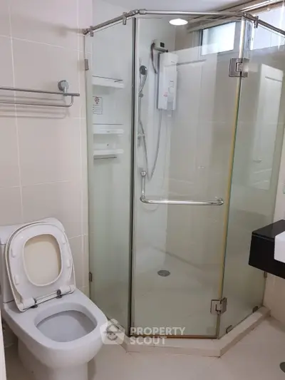 Modern bathroom with glass shower enclosure and sleek fixtures.