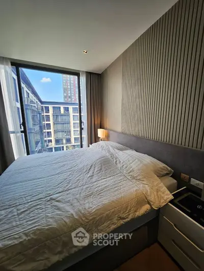 Modern bedroom with large window offering stunning city view in luxury apartment