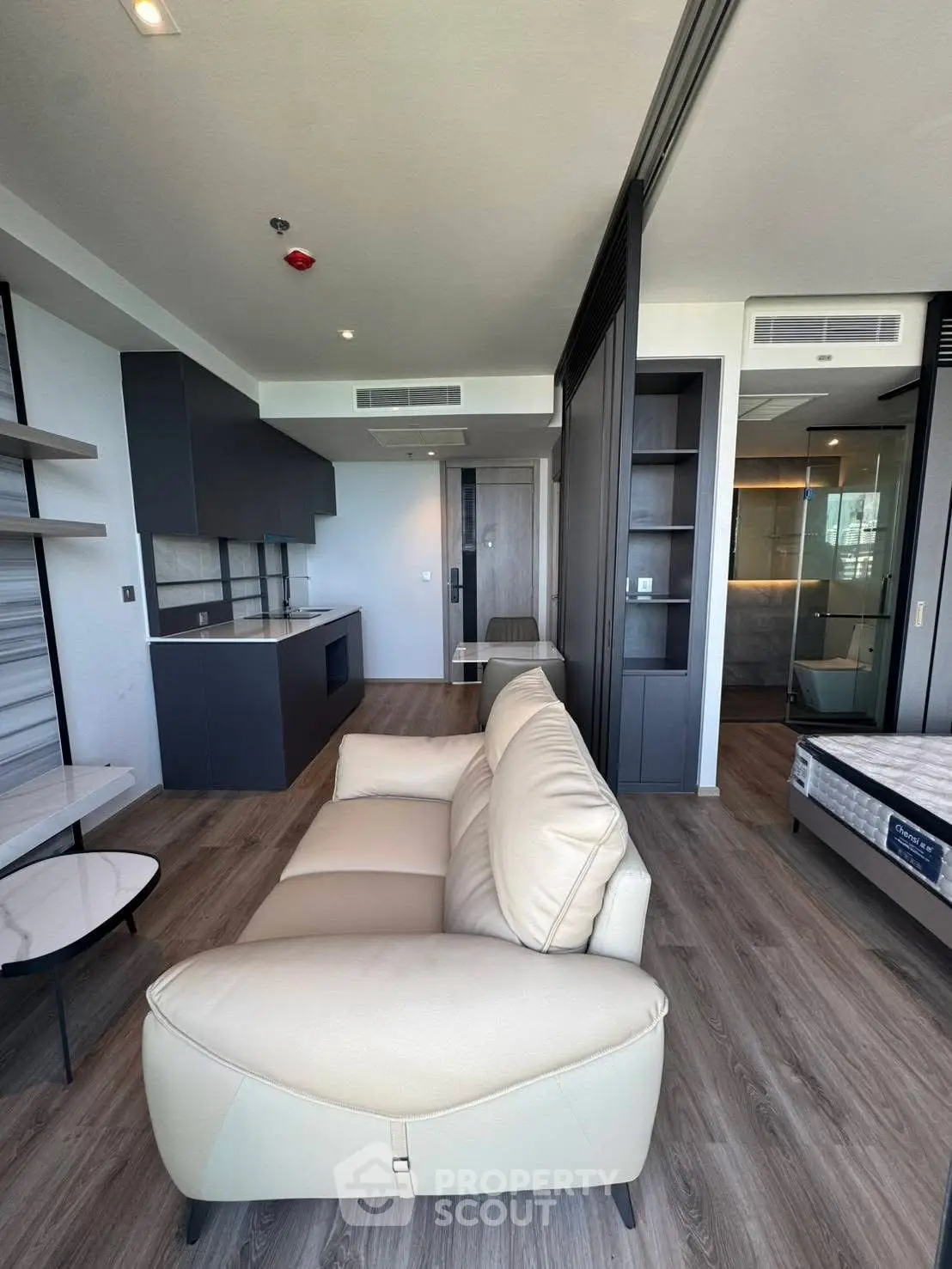 Modern living room with sleek design and open kitchen layout in luxury apartment.