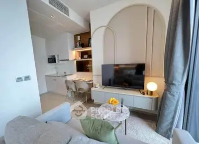 Modern living room with open kitchen, stylish decor, and cozy seating area.