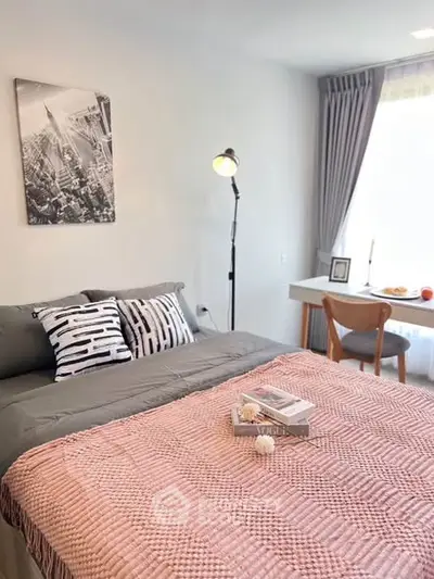 Cozy bedroom with stylish decor, featuring a comfortable bed, modern lamp, and a bright window view.