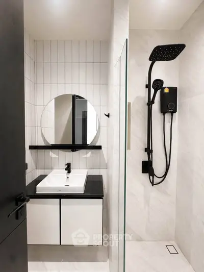 Modern bathroom with sleek black fixtures and round mirror