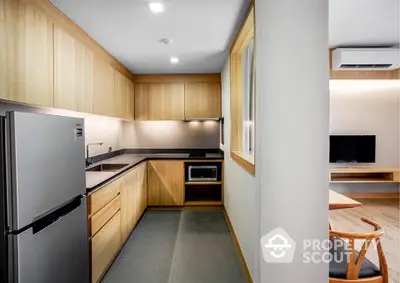 Modern kitchen with sleek wooden cabinetry and stainless steel appliances