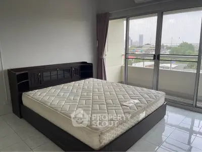 Spacious bedroom with large windows and city view, featuring a comfortable bed and modern design.