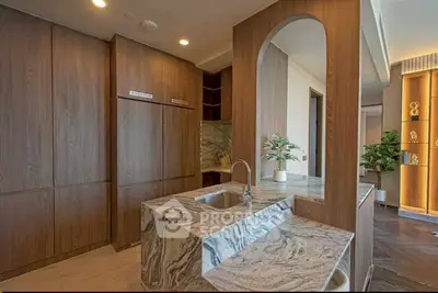 Luxurious modern kitchen with elegant marble countertops and sleek wooden cabinetry.