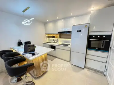 Modern kitchen with sleek white cabinets, island seating, and built-in appliances for a stylish culinary experience.