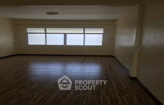 Spacious empty living room with large windows allowing natural light, perfect for custom interior design.