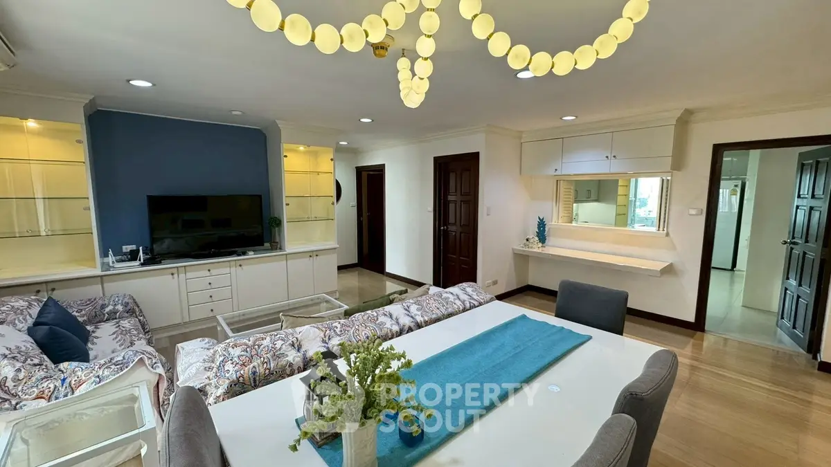 Spacious living room with elegant decor and modern lighting in a stylish apartment.