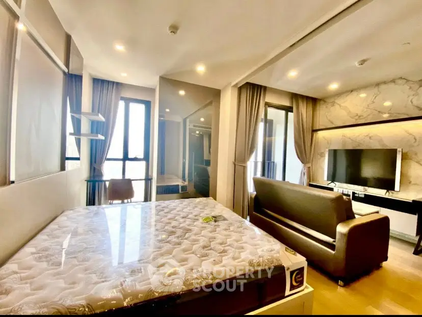 Modern studio apartment with stylish decor and large windows for natural light.