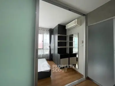 Modern bedroom with sleek design and ample natural light, featuring built-in storage and air conditioning.