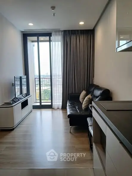 Modern living room with sleek furniture and large window offering city view
