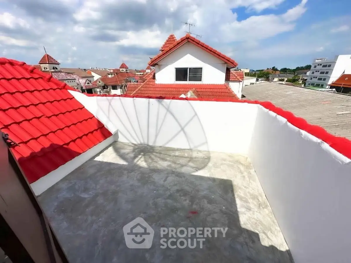 Charming rooftop terrace with red-tiled roofs and scenic sky views, perfect for relaxation.