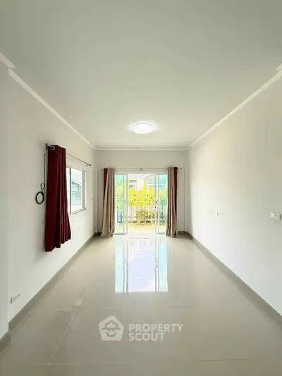 Spacious empty living room with large windows and garden view, perfect for customization.