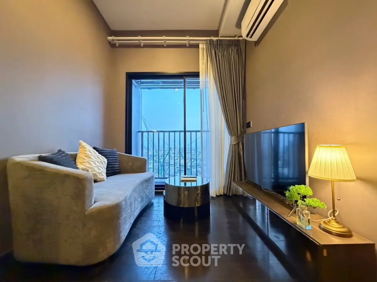 Cozy living room with modern sofa, TV, and balcony view in stylish apartment.