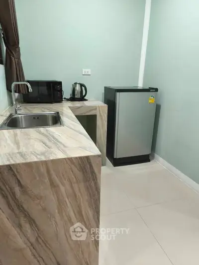 Compact kitchen with modern appliances and sleek marble countertop