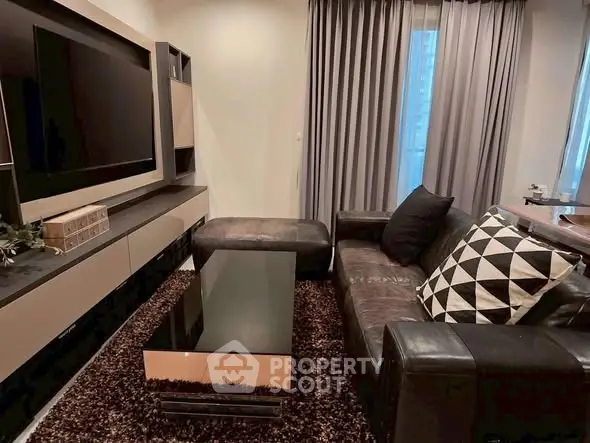 Modern living room with sleek furniture and large TV, perfect for relaxation and entertainment.