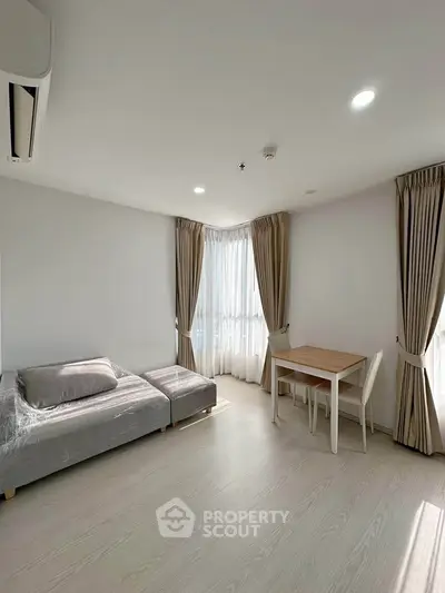 Bright and airy living room with modern furniture and large windows in a stylish apartment.
