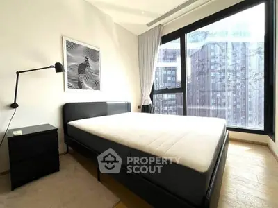 Modern bedroom with large window and city view in urban apartment