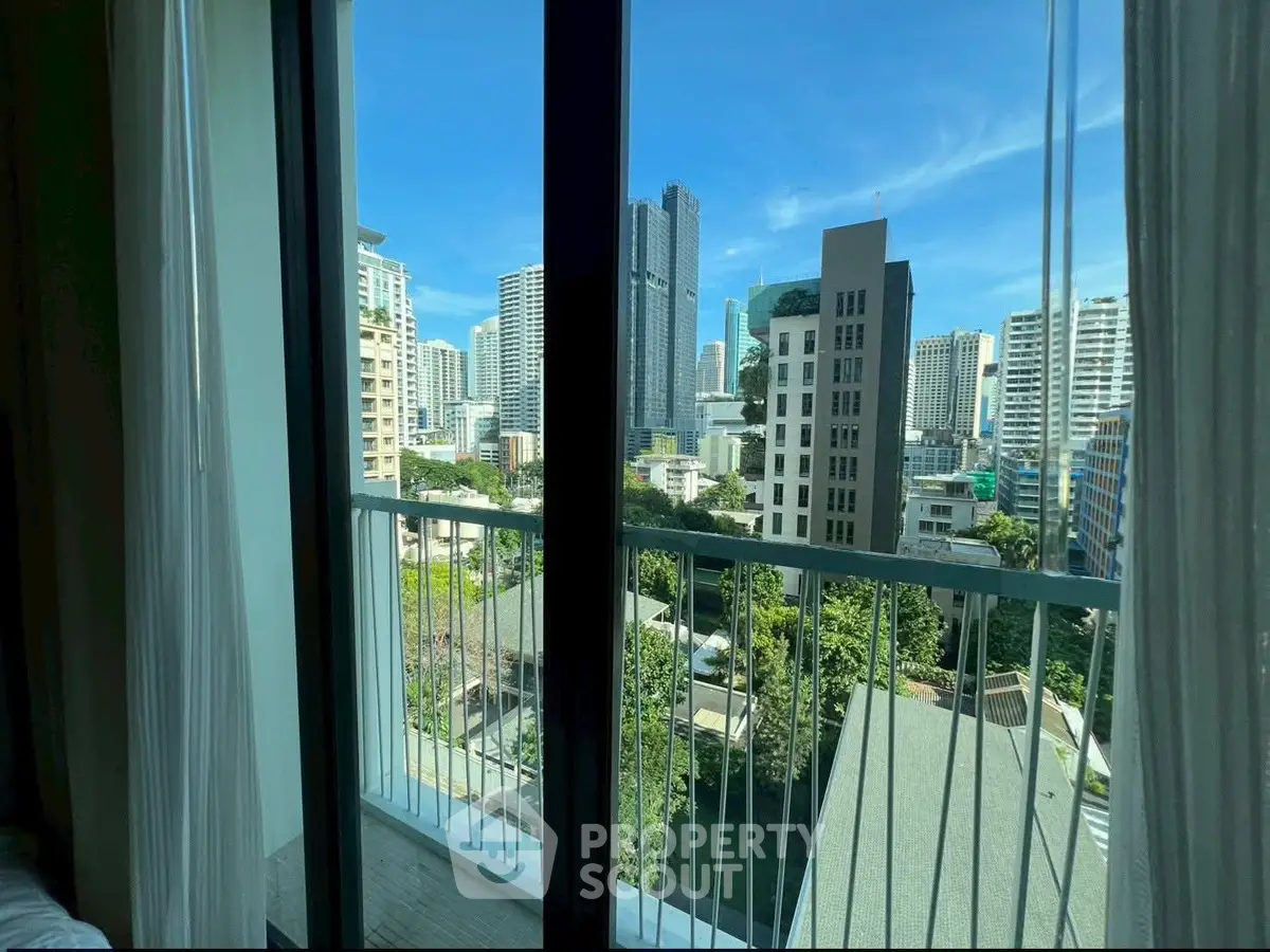 Stunning cityscape view from a modern apartment balcony with clear blue skies.