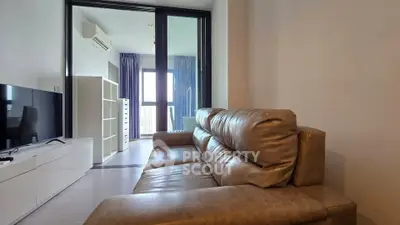 Modern living room with leather sofa and balcony view in a stylish apartment.