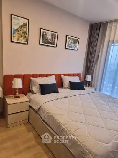 Modern bedroom with stylish decor and large window offering natural light.