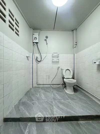 Spacious bathroom with modern fixtures and tiled flooring in a real estate property.