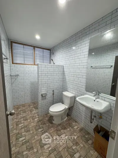 Spacious modern bathroom with white subway tiles and natural light