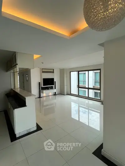 Spacious modern living room with large windows and sleek white flooring