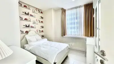 Charming bedroom with cozy decor and ample natural light, perfect for relaxation.