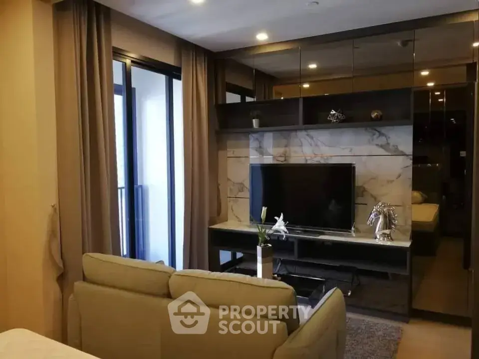 Modern living room with sleek design and large TV, featuring elegant decor and cozy seating.