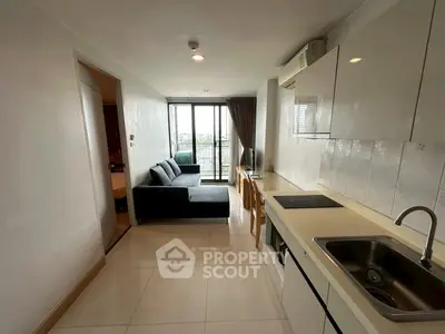 Modern apartment with open kitchen and cozy living area, featuring a balcony view.