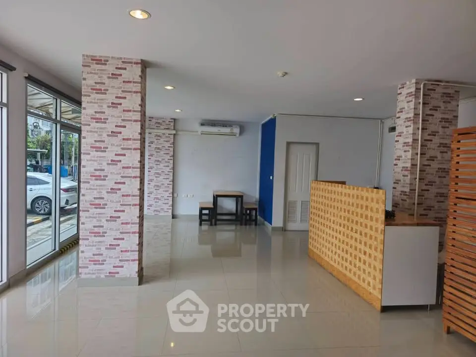 Spacious modern interior with large windows and stylish brick accents, perfect for versatile living or office space.