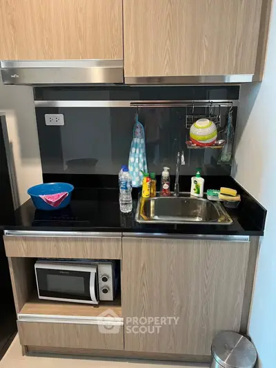 Modern compact kitchen with wooden cabinets and sleek appliances, perfect for urban living.