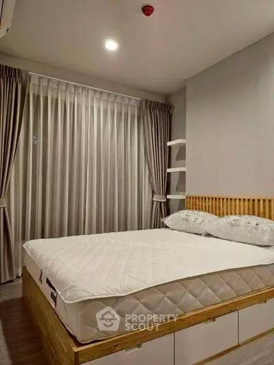 Modern bedroom with stylish decor and large window, featuring a comfortable bed and elegant curtains.