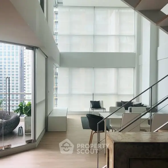 Luxurious modern living room with floor-to-ceiling windows and balcony view in high-rise apartment.