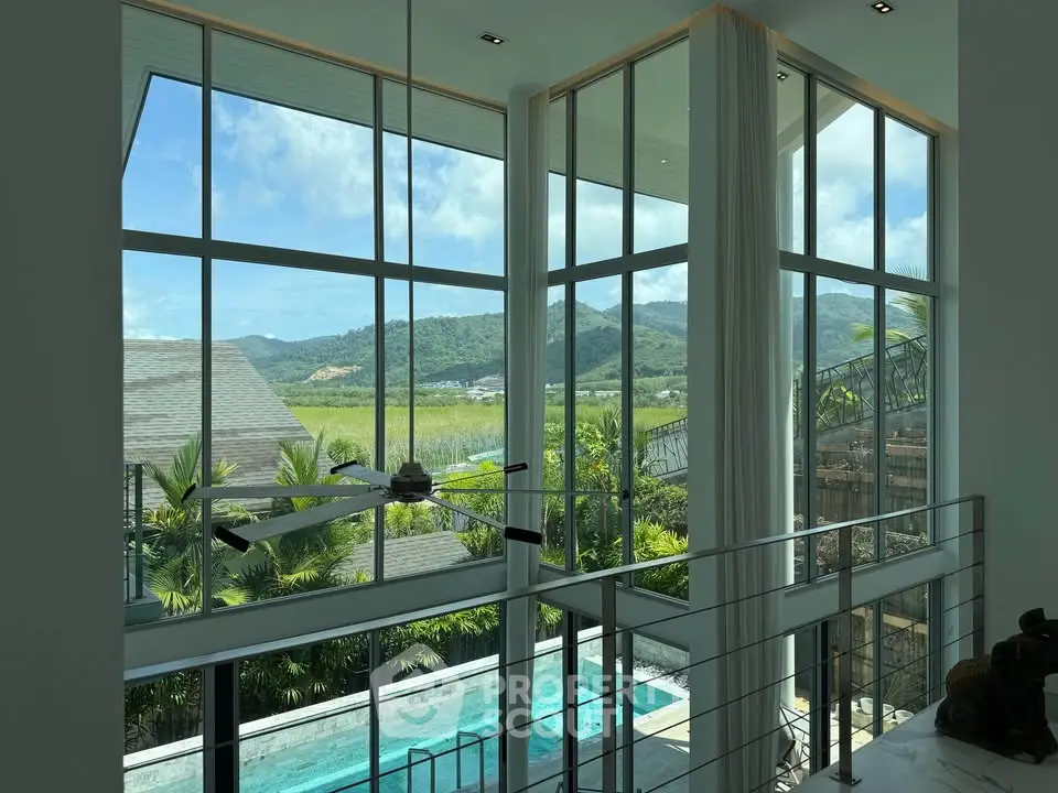 Luxurious modern home with floor-to-ceiling windows offering stunning mountain and pool views.