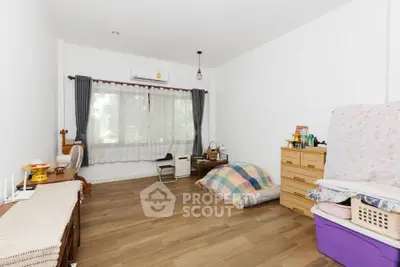 Spacious minimalist bedroom with wooden flooring and natural light