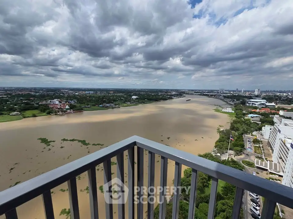 Stunning river view from high-rise balcony with expansive cityscape and lush greenery.