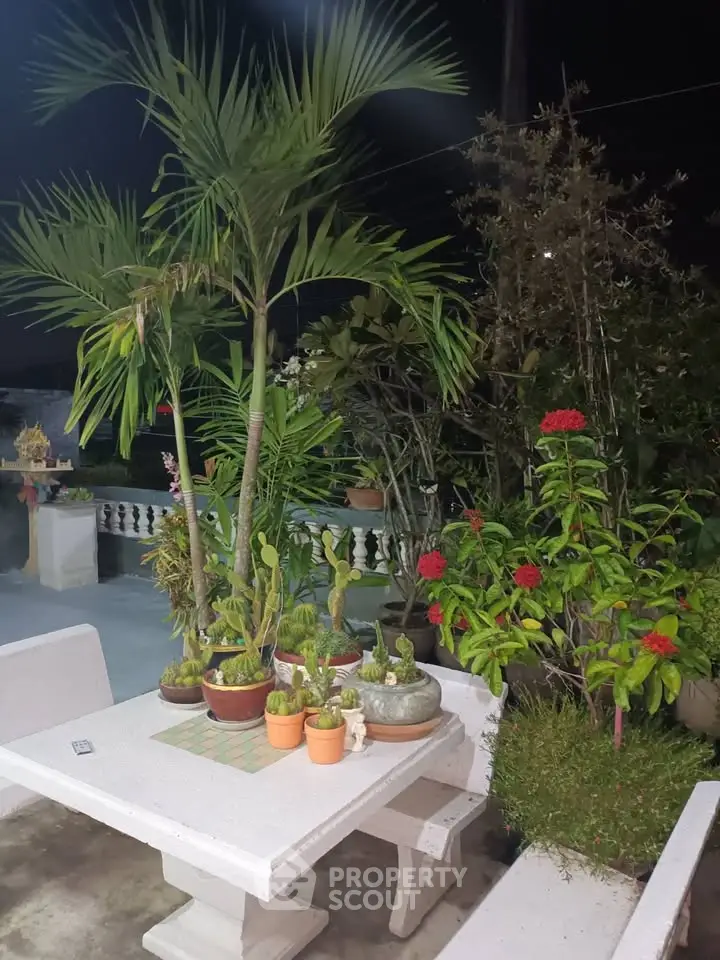 Charming garden patio with lush greenery and elegant stone seating, perfect for outdoor relaxation.