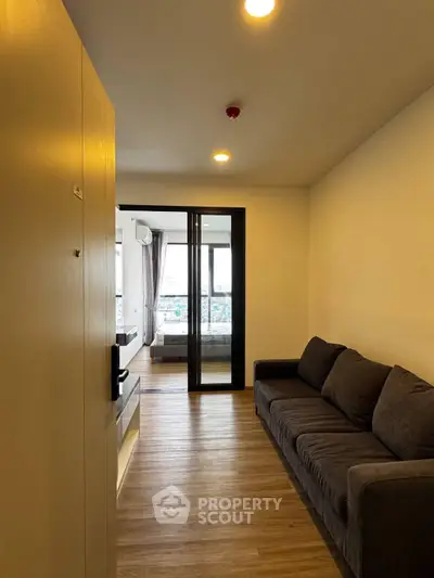 Modern apartment entrance with cozy living area and view of bedroom