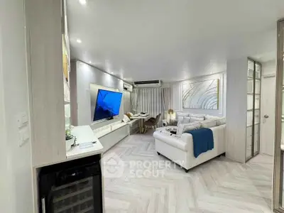 Modern living room with sleek design, large TV, and cozy seating area.