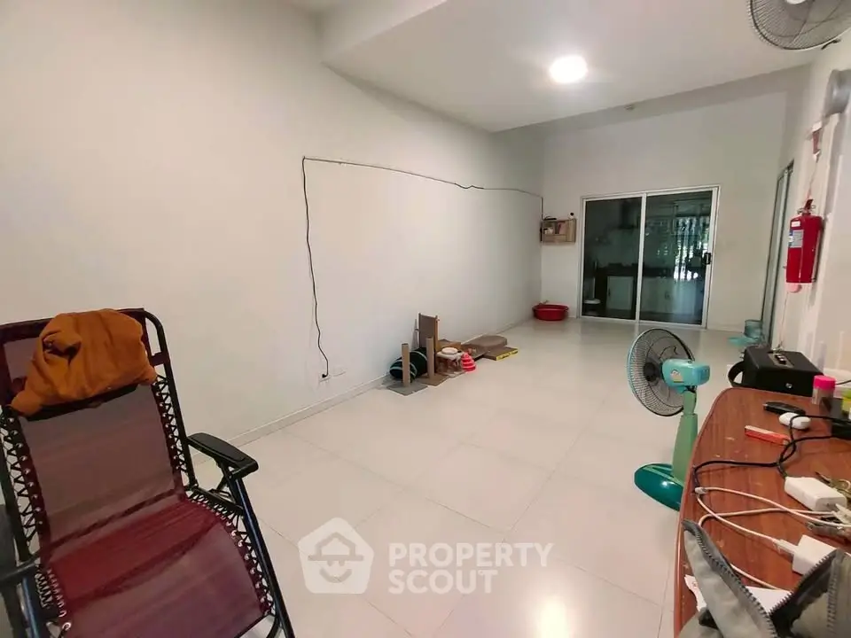 Spacious unfurnished room with tiled flooring and sliding glass doors, ideal for customization.