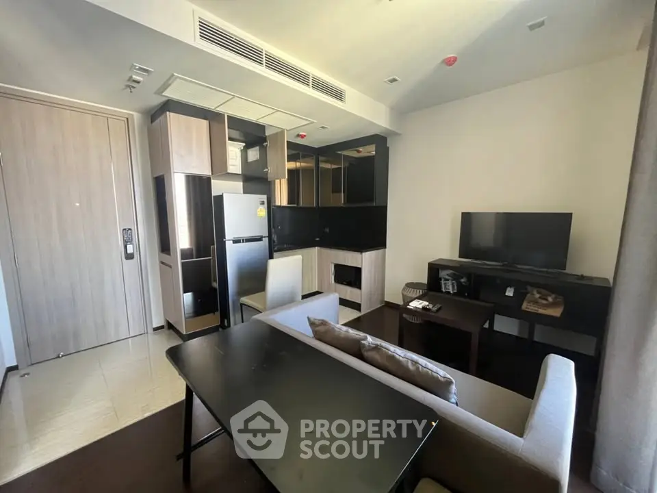 Modern living room with open kitchen, sleek furniture, and contemporary design in a stylish apartment.
