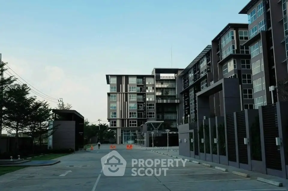 Modern apartment building with spacious parking area and contemporary design.