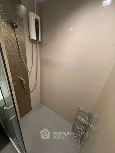 Modern bathroom with sleek shower and water heater, featuring minimalist design and neutral tiles.