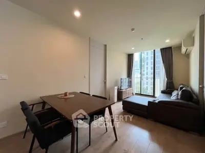 Modern living room with city view, stylish furniture, and natural light.